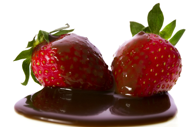 two strawberries drenched in chocolate syrup