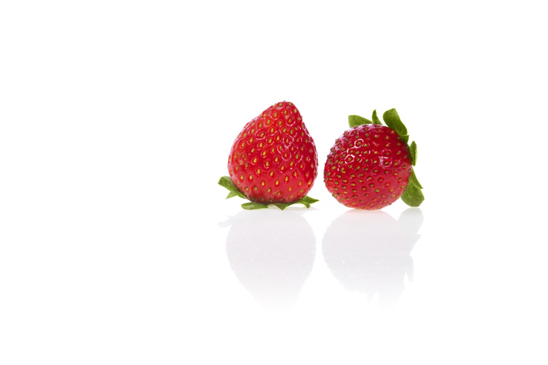 pair of strawberries against white background with copy space for adve