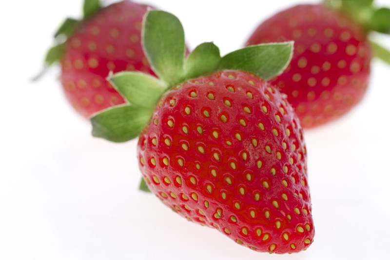 close up shot of three strawberries lying 