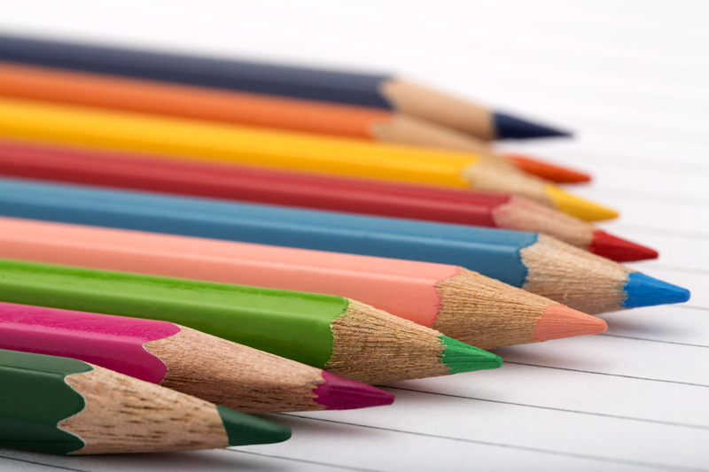 multi colour pencils in a row against white background 