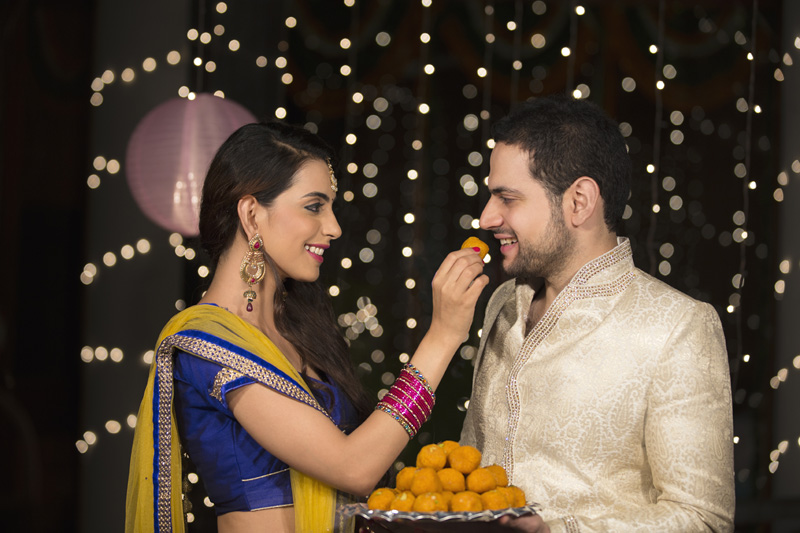 couple enjoying sweets at diwali