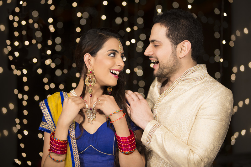 husband gifting jewellery to the surprised wife 