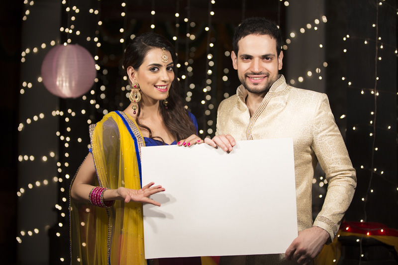 couple pointing towards a message board on diwali