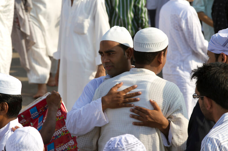 men greeting each other at mosque 