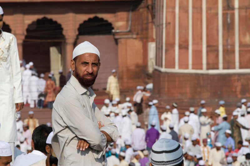 mulsim man watching while people in the background for prayer 
