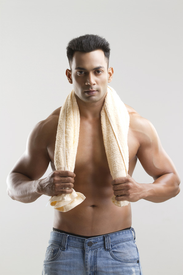 man with muscular built posing with a towel