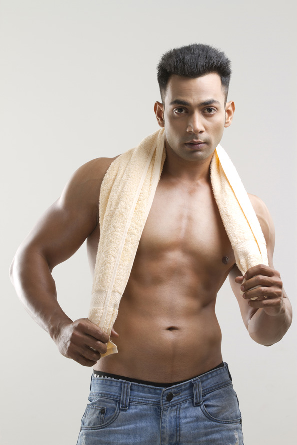 man with muscular built posing with a towel