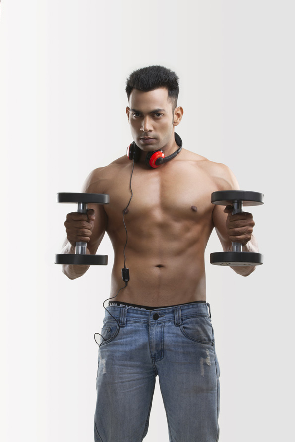 man posing with dumbbells and headphones