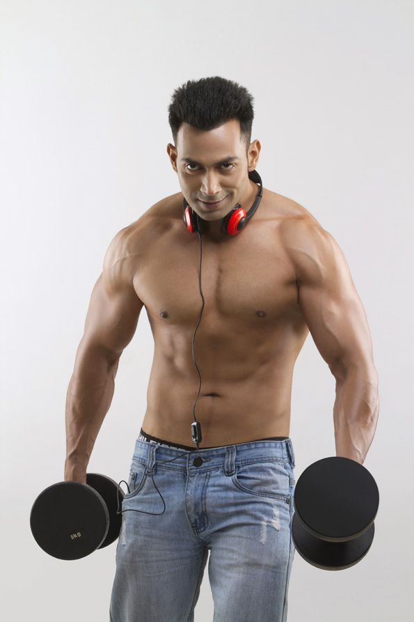 man posing with dumbbells and headphones