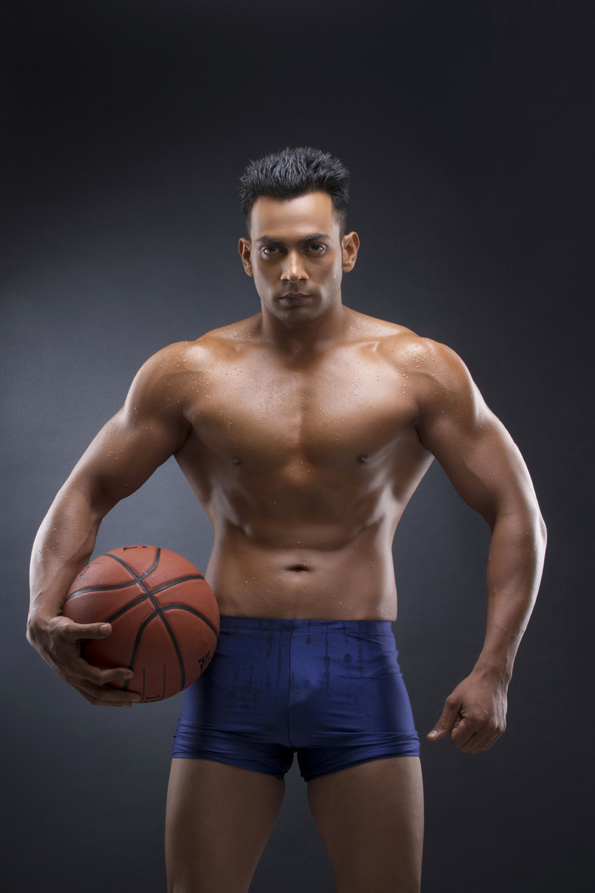 man with a well built physique holding a basketball