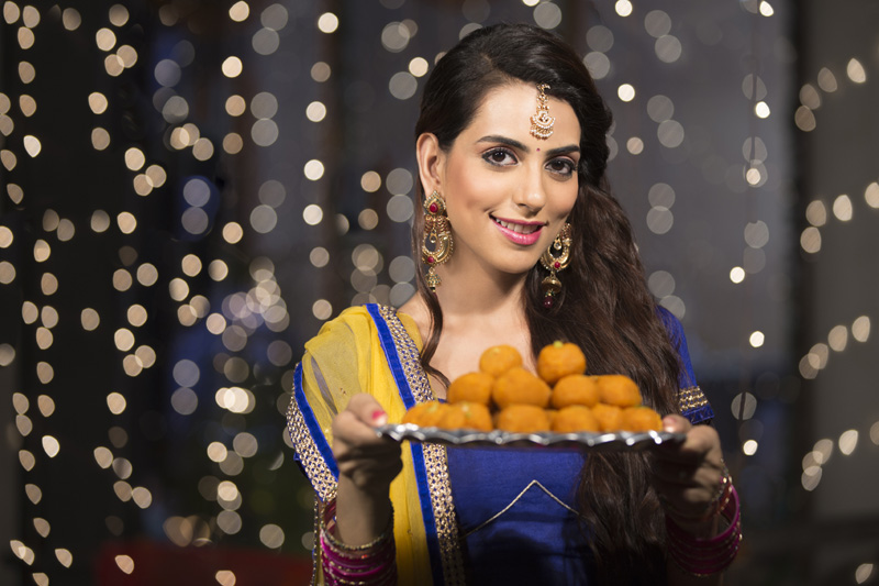 woman with a plate of ladoos