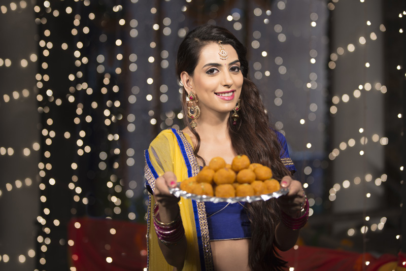 woman with a plate of ladoos 