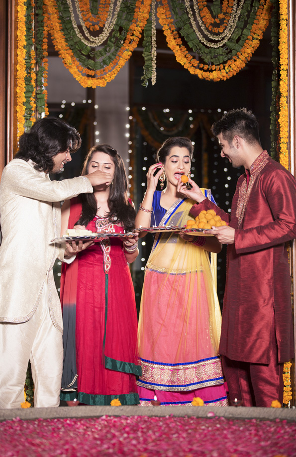 couples feeding sweets to each other on diwali