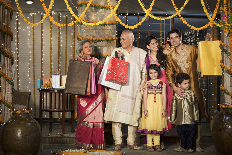 family with diwali gifts standing at entrance of house 