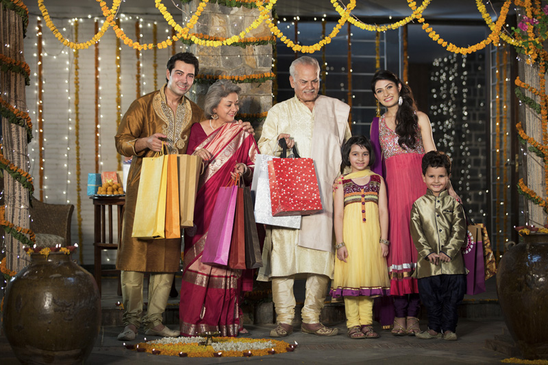 family with diwali gifts standing at entrance of house 