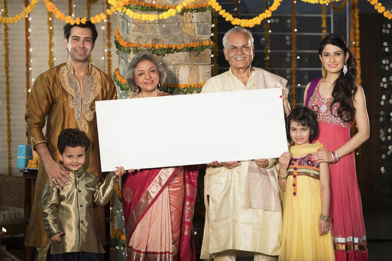 family standing at entrance with message board on diwali