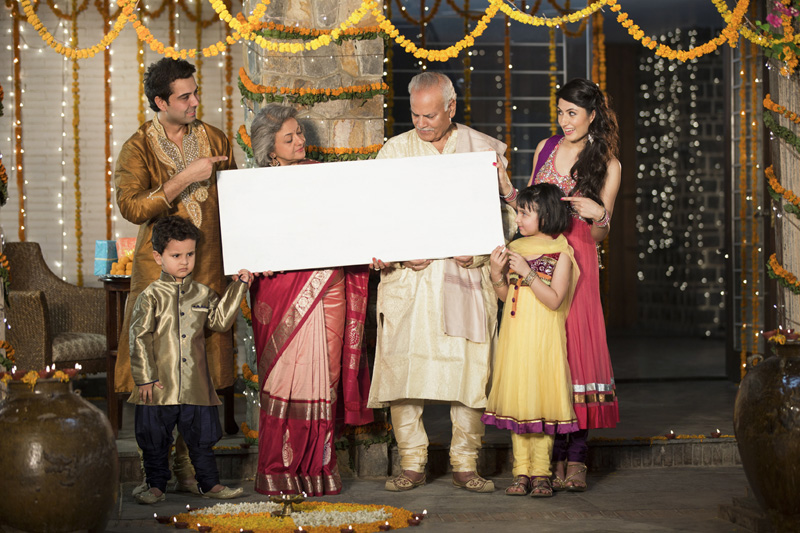 family standing at entrance with message board on diwali