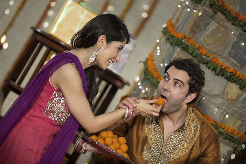 wife feeding ladoo to husband on diwali