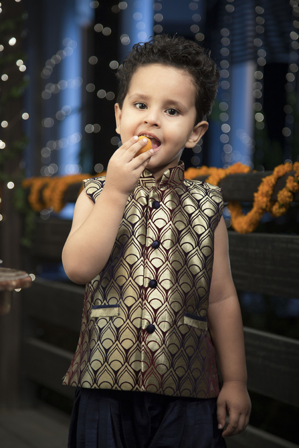 kid dressed in traditional outfit having sweets