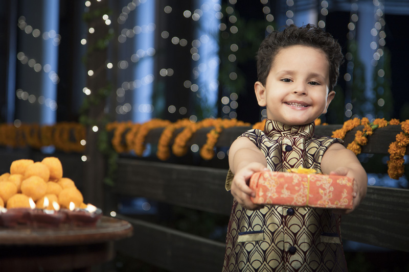 cheerful young boy eating sweets on Diwali