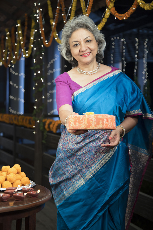 cheerful old woman offering a present on diwali