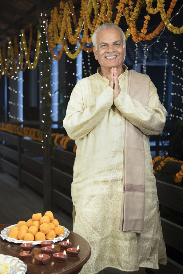 smiling old man welcoming guests on diwali
