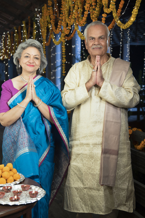 smiling old couple welcoming guests on diwali