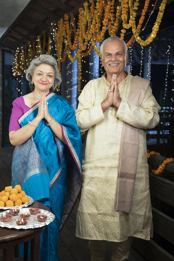 smiling old couple welcoming guests on diwali
