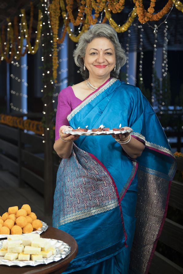 smiling old woman welcoming guests on diwali