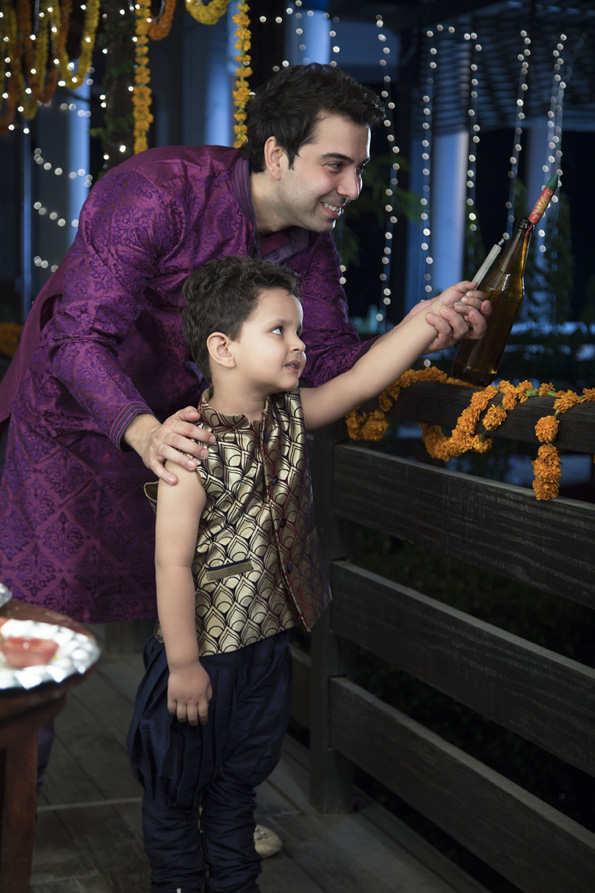 young father with his son lighting a cracker