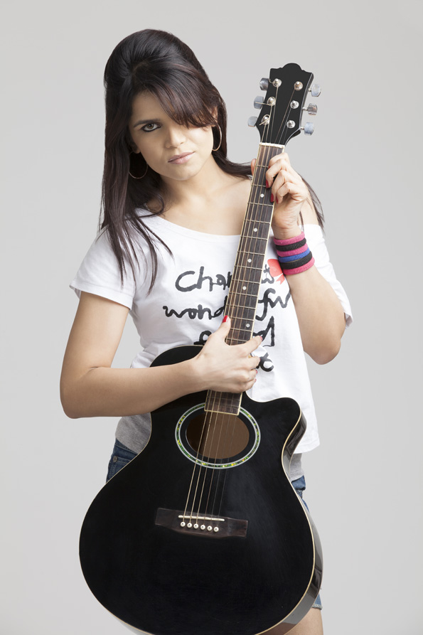 girl wearing short denims posing with a guitar