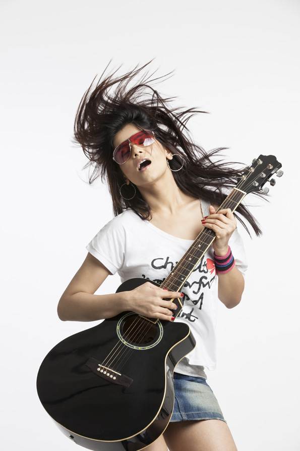 beautiful teenager playing guitar on white background
