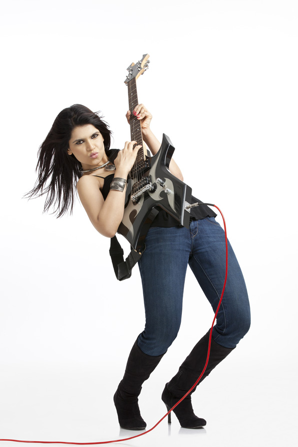 full length portrait of female rockstar holding a funky guitar