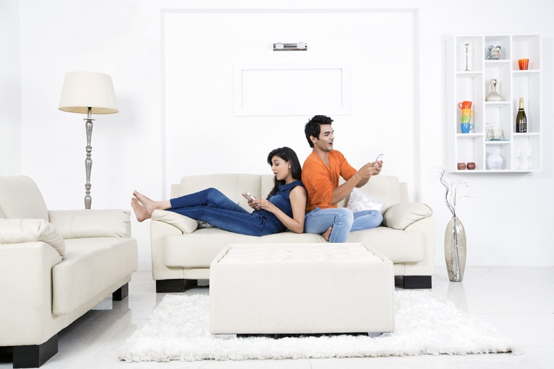 couple on couch using mobile phone