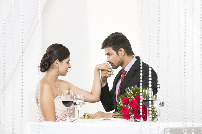 man kissing girl hand on romantic dinner