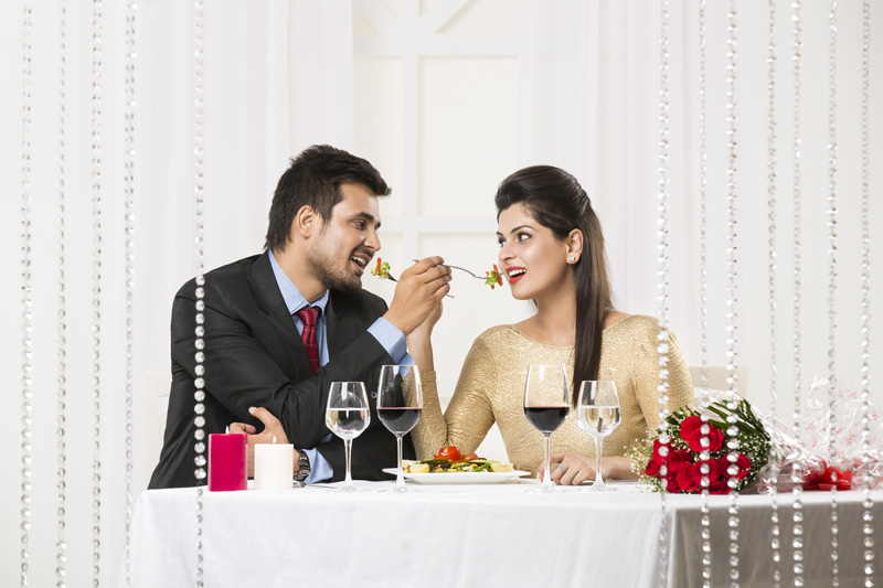 couple feeding each other on romantic dinner