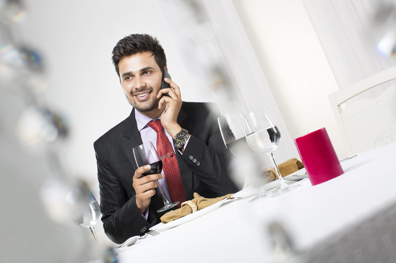 businessman on phone with a glass of wine