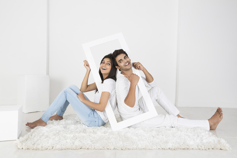 couple posing with frame on white background