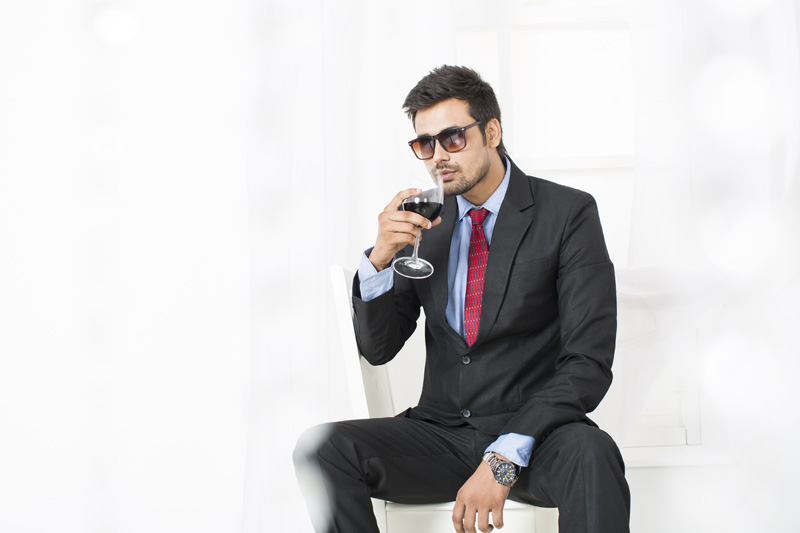 man in formals drinking wine 