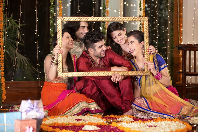 group of friends posing in wooden frame on diwali festival