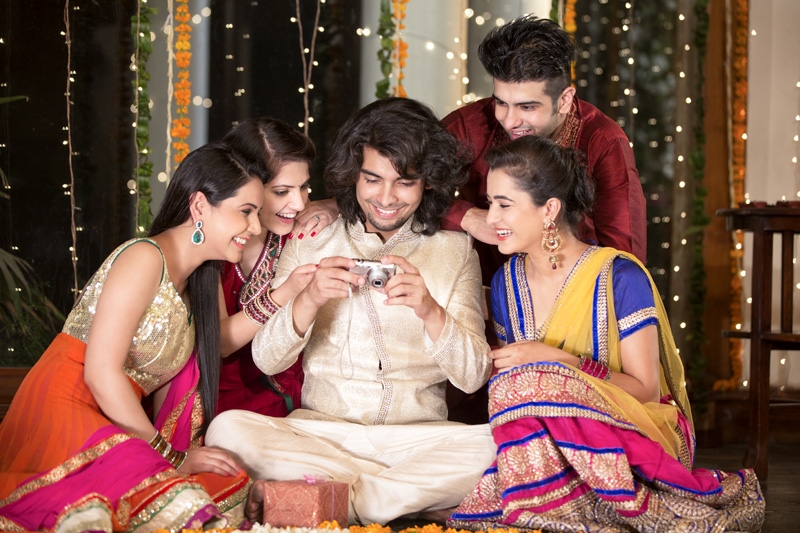 group of friends checking pictures clicked on diwali 