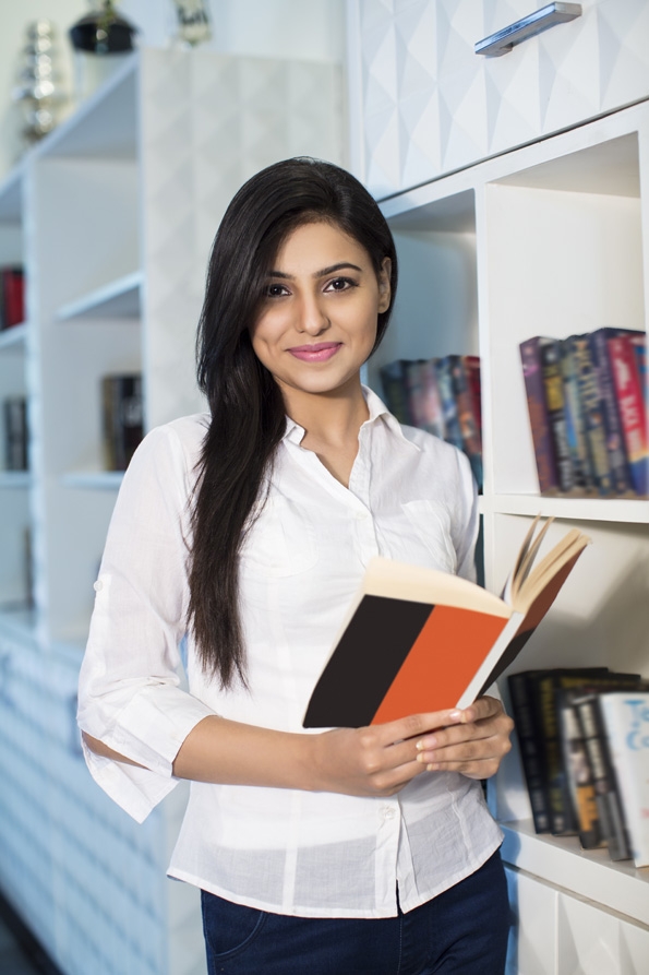 girl smiling and posing with book