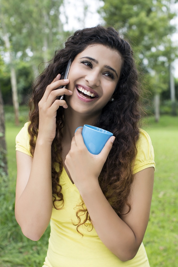 girl attending call while having coffee