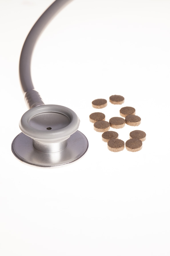 medical pills and stethoscope on white background