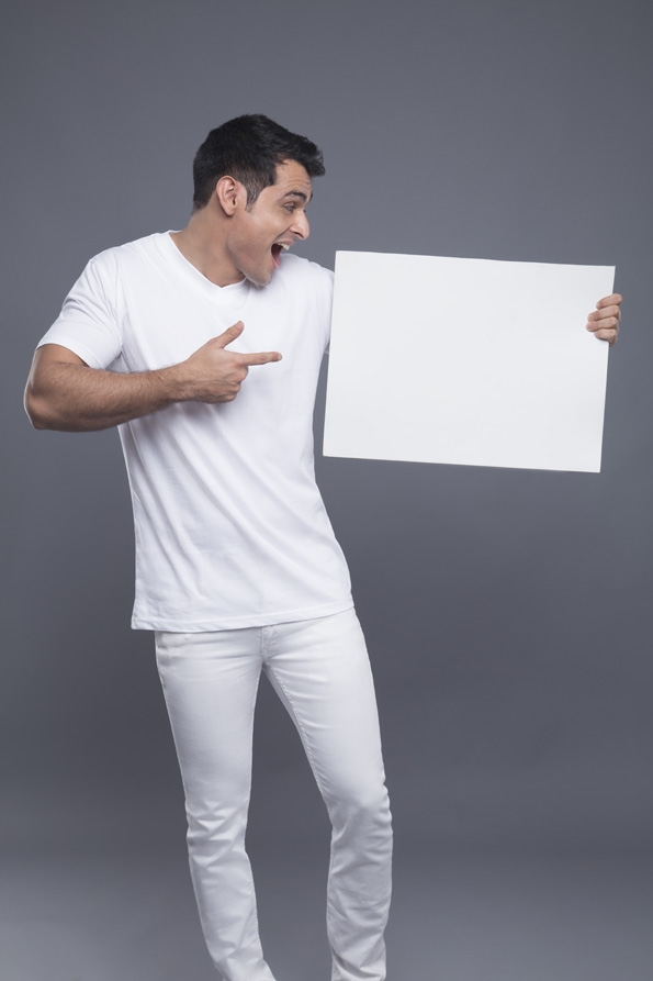 man in white posing with a message board 