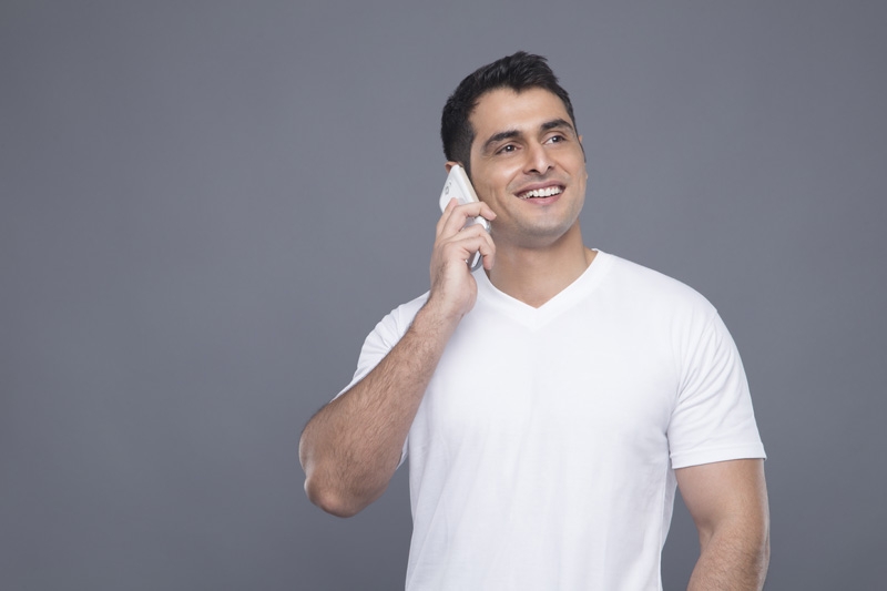man in white t shirt talking on phone 