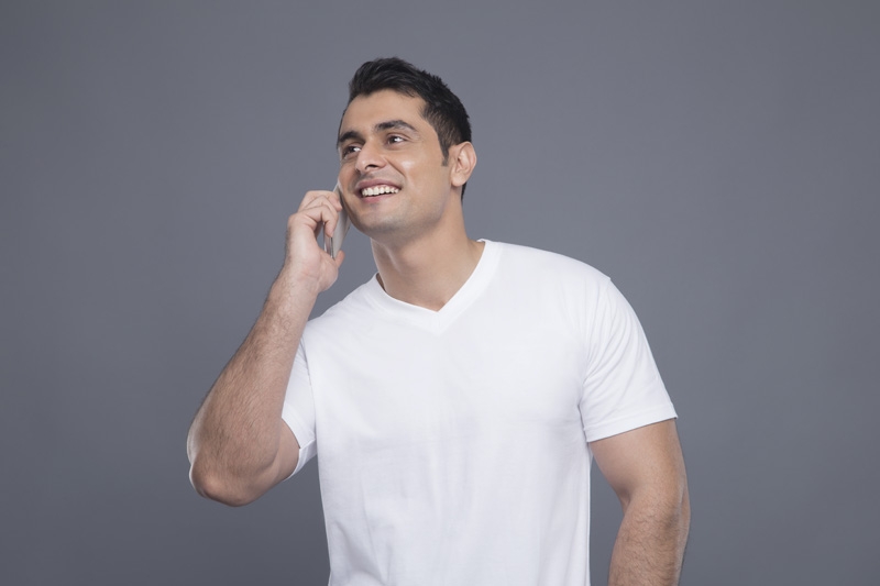 man in white t shirt talking on phone 