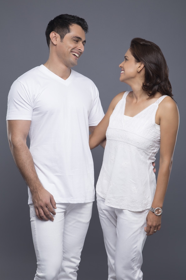 smiling couple standing against grey background