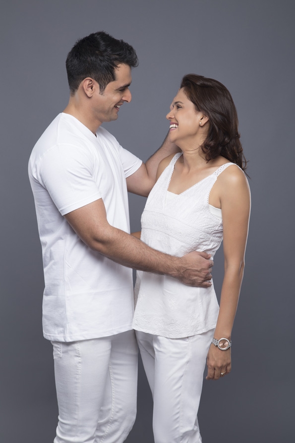 smiling couple standing against grey background