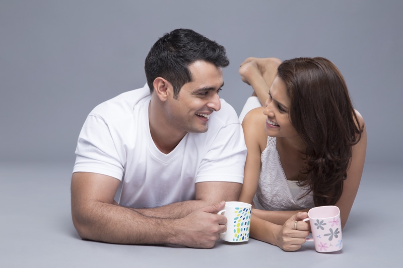 couple lying with front view drinking coffee